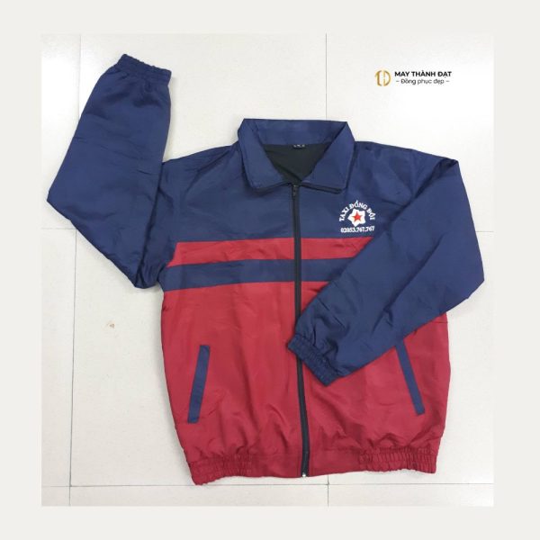 Áo khoác gió đồng phục phối màu xanh navy – đỏ đô unisex, ảnh chụp sản phẩm thật may tại May Thành Đạt