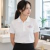 Nhân viên nữ mặc áo polo công ty trong showroom