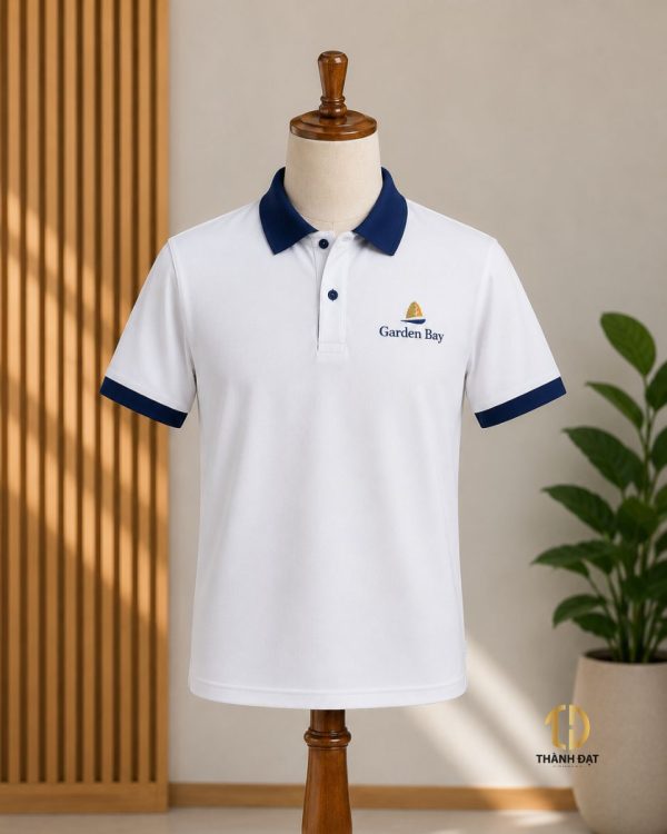 Mẫu áo polo đồng phục khách sạn màu trắng phối xanh navy trên canh gỗ